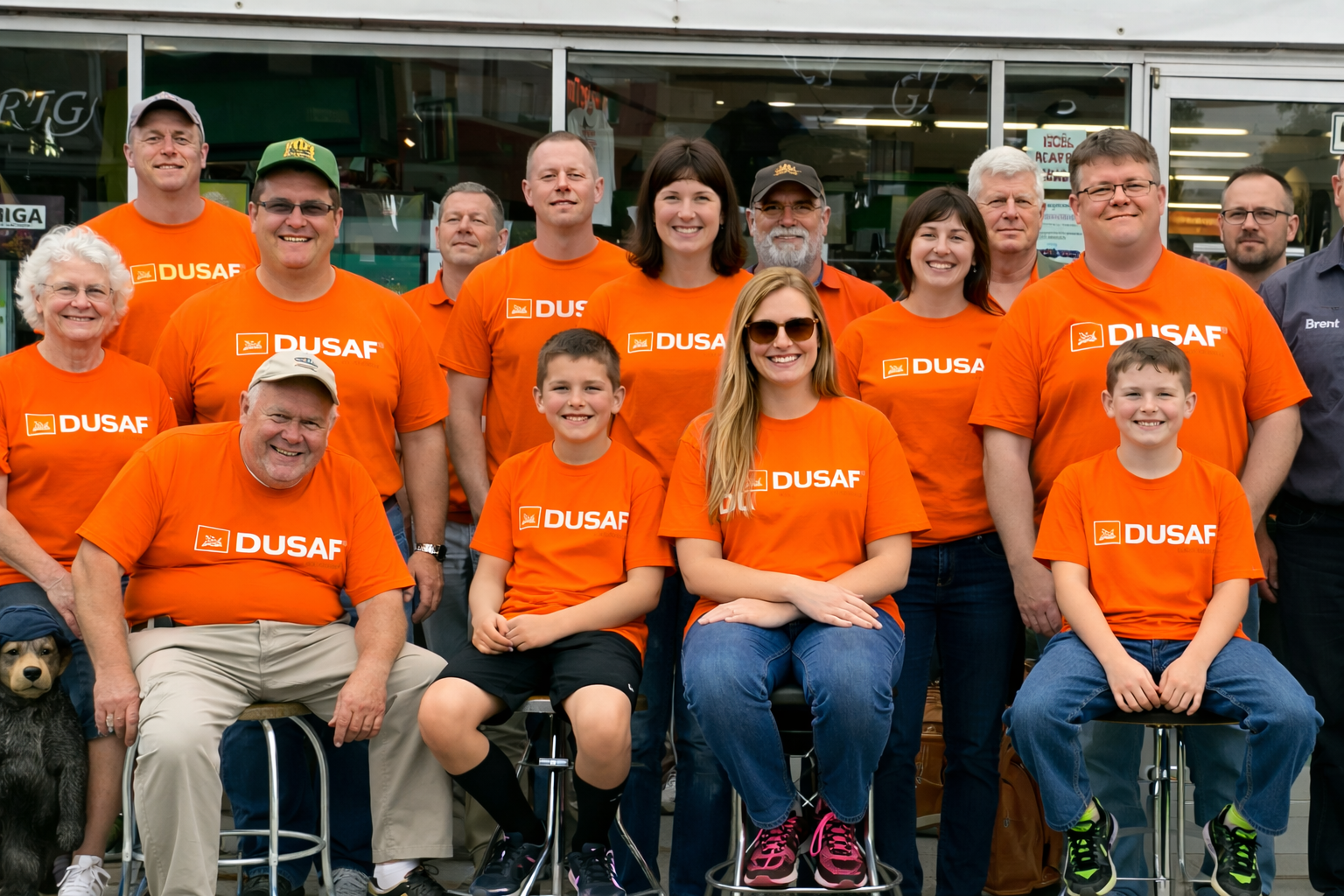 Group wearing orange shirts, smiling together.